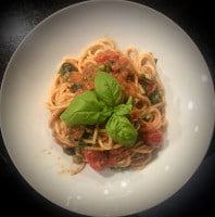 Spaghetti alla Puttanesca mit Basilikum serviert