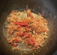 Zwiebeln, Tomatenmark und Chili für den Hackfleisch-Kartoffelbrei-Auflauf dünsten an