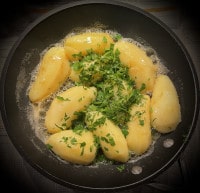 Über die Kartoffeln in aufgeschäumter Butter kommt dann frische Petersilie
