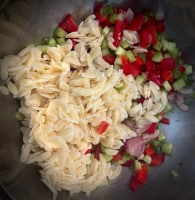 Gurke, Tomate und Paprika gewürfelt mit Frühlingszwiebeln, Knoblauch, den roten Zwiebeln und die Risoni Nudeln für den Risoni Salat
