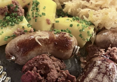 Wellwurst auf frischem Sauerkraut mit Kartoffelpüree